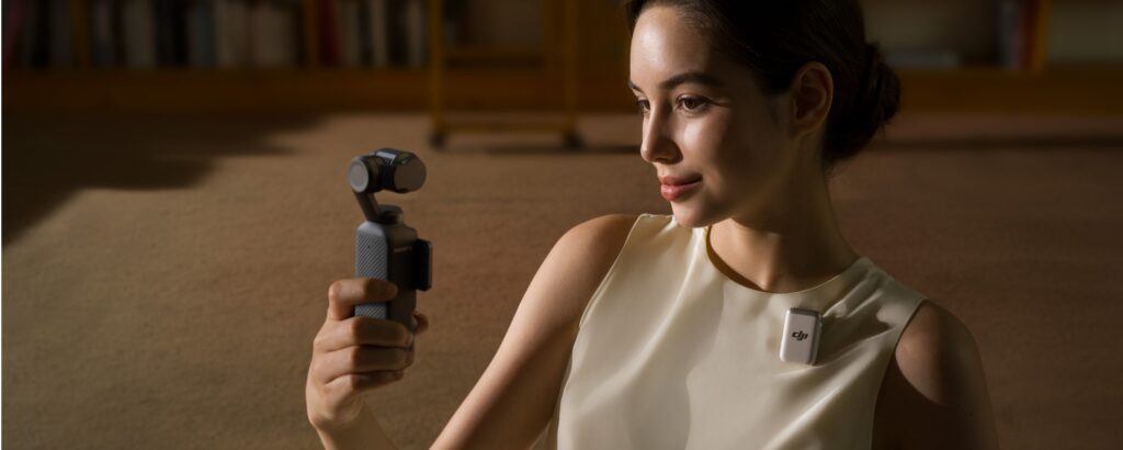 A woman holding a Pocket 3 wearing a DJI Mic2.