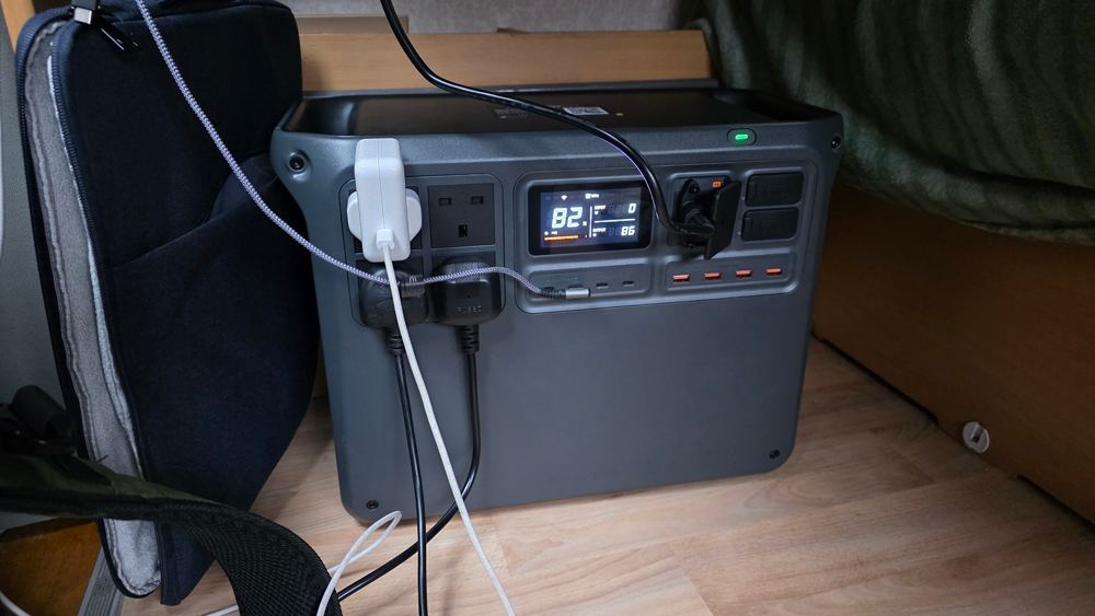 The DJI Power 2000 in situ under a table in a motorhome with laptop power leads plugged in.