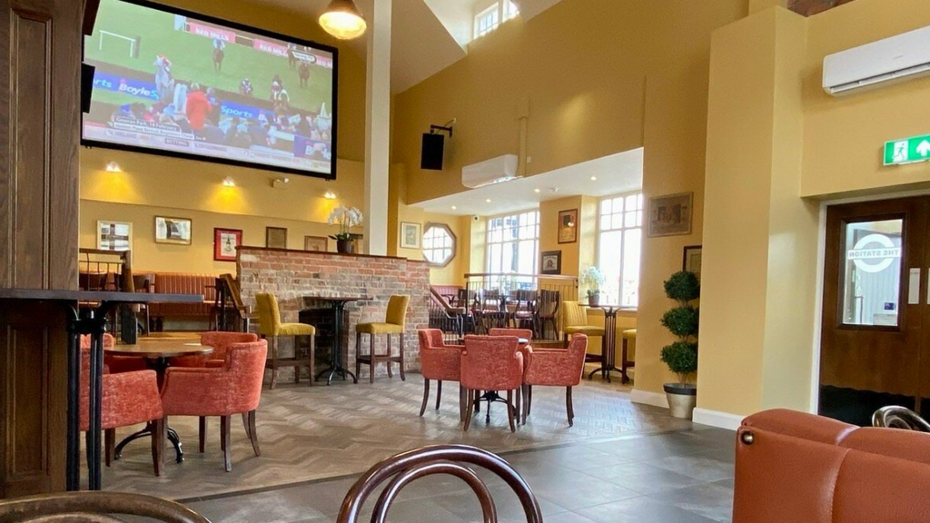The interior of the Station Bar in Portrush, showing the dance floor and a large TV screen for displaying live sports.